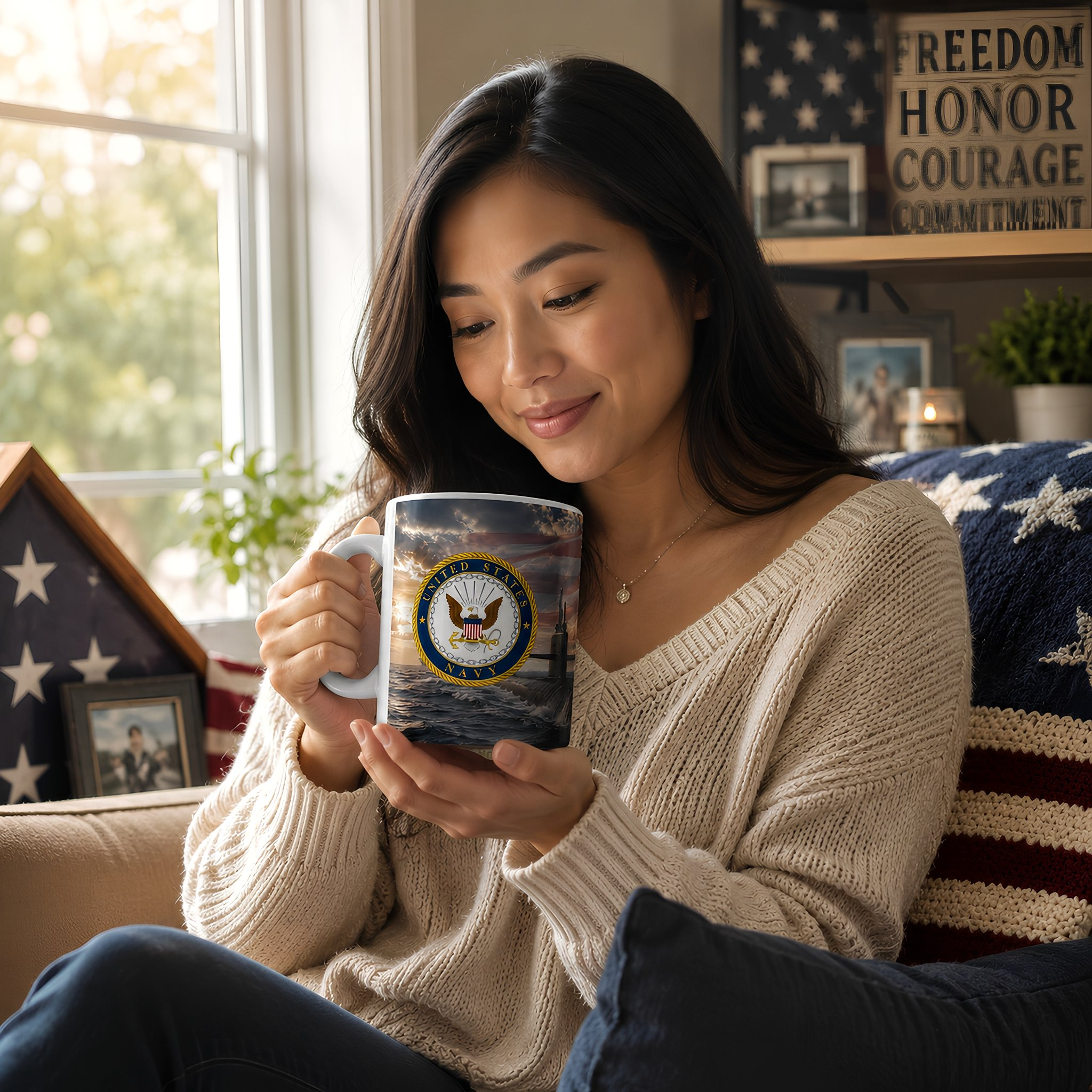 A woman sits on a couch, holding a mug with a design featuring the United States Navy seal.