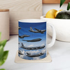 A white mug with a printed image of fighter jets flying in formation against a blue sky with clouds.