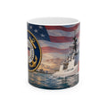 A mug featuring a design of a U.S. Coast Guard ship sailing on the water, with an American flag in the background and a nautical emblem on the side.