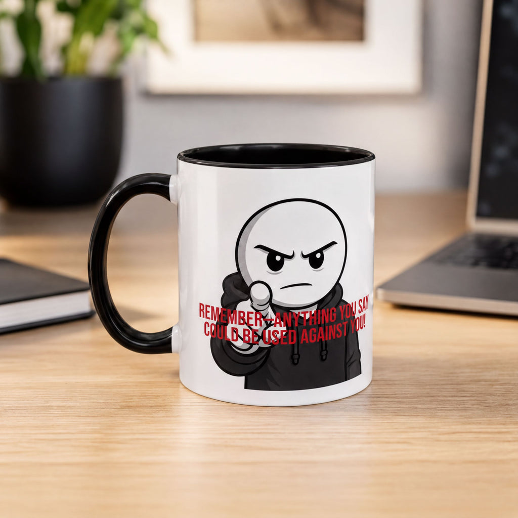 A white mug with a cartoon character and text printed on it, placed on a wooden desk.