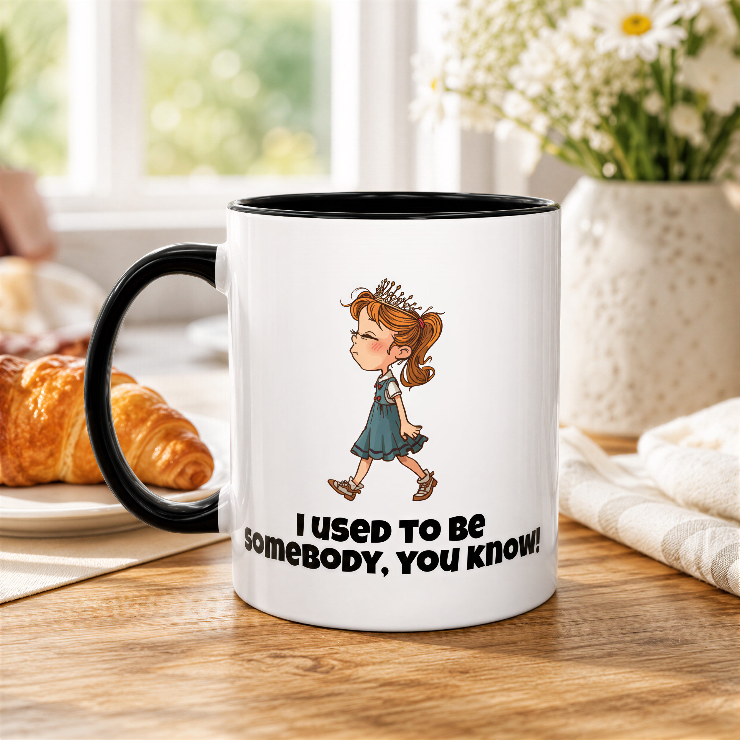 A white mug with a black handle, featuring a cartoon image of a young girl and the text "I used to be somebody, you know!"