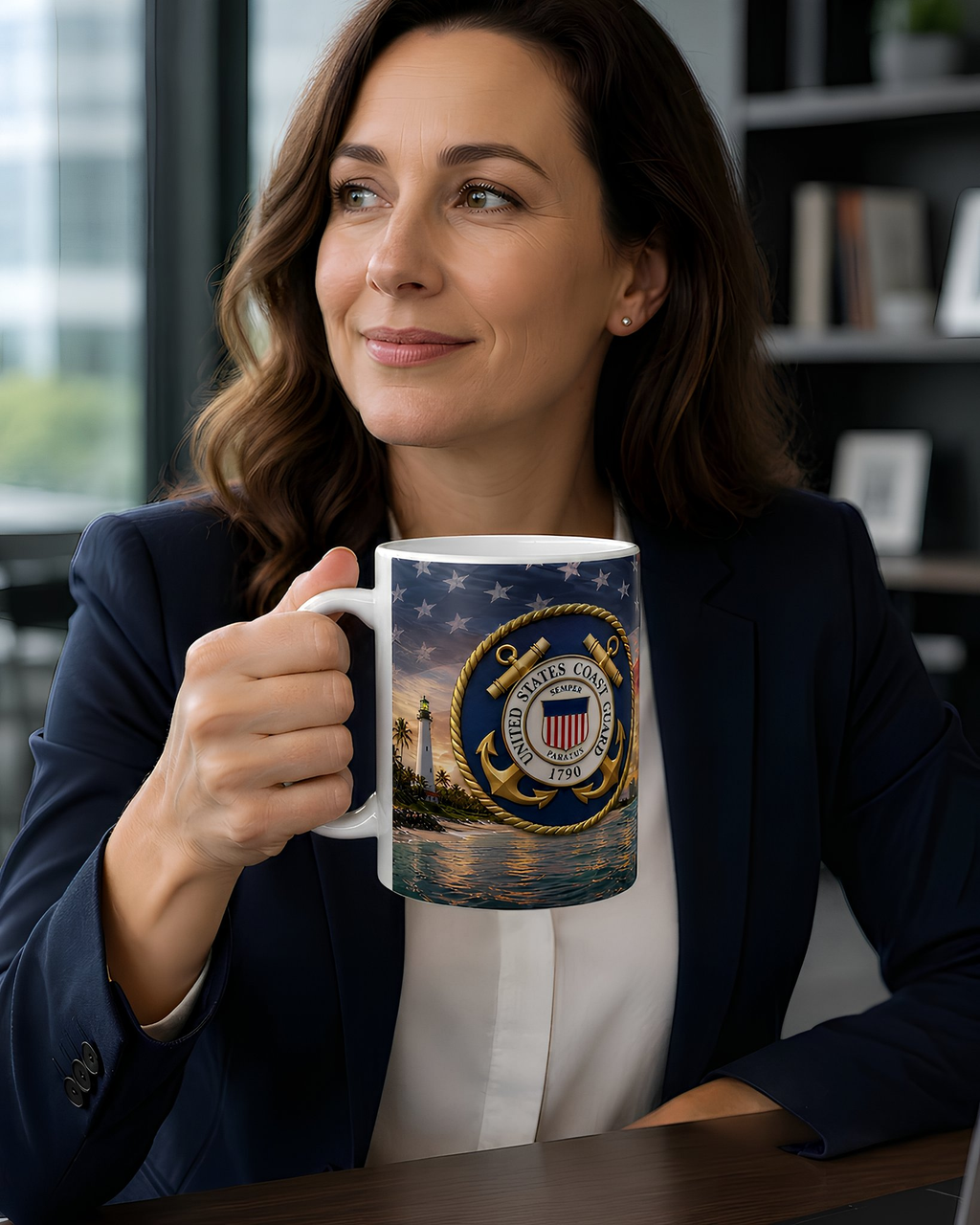 A woman in a navy blue blazer holds a mug with a navy blue and gold design featuring a lighthouse and stars, with a serene body of water and a sunset in the background.
