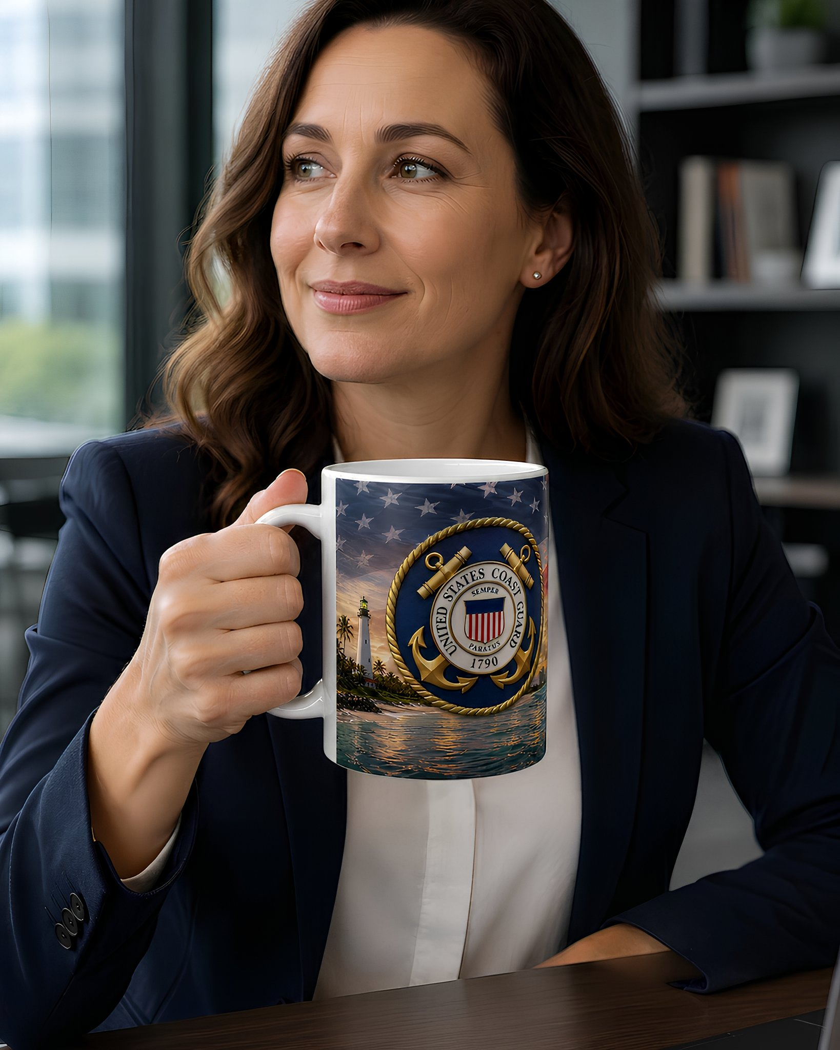 A woman in a navy blue blazer holds a mug with a navy blue and gold design featuring a lighthouse and stars, with a serene body of water and a sunset in the background.