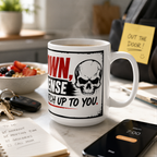 a white mug with a skull design and the text "OWN, SENSE, CHATCH UP TO YOU." The mug is placed on a table with a bowl of fruit, a notebook, a smartphone, a keychain, and a yellow sticky note.