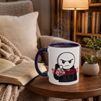 A mug with a cartoon character and text sits on a wooden table, with a book and a plant nearby.