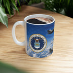 A mug with a design featuring the United States Air Force emblem, including an airplane and clouds, on a wooden surface.