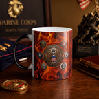 A mug with a design featuring the United States Marine Corps seal, surrounded by flames and other military memorabilia, such as a pen and a coin.