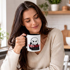 A woman with long brown hair is holding a mug with a cartoon character on it, and she is smiling.