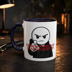 A white mug with a cartoon character and text printed on it, sitting on a wooden surface.